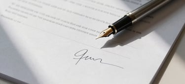 Close-up overhead of a legal document on a pale desk, a fountain pen resting on the page mid-signature, soft north-facing window light casting gentle shadows across the paper edge