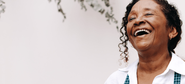 senho sorrindo utilizando aparelhos auditivos