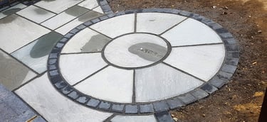 Grey sandstone circle paving slabs with charcoal edging