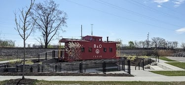 A RED CABOOSE TRAIN CAR SITTING ON A TRACK IN WORTHINGTON OHIO