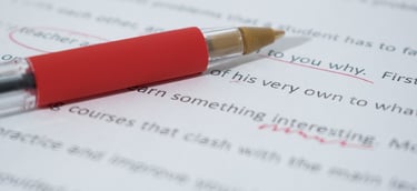 an essay being graded with red pen