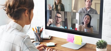 a woman sitting at a computer screen with a video chat
