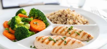 prato equilibrado com vegetais, proteína magra e grãos integrais em ambiente de consultório nutricional.