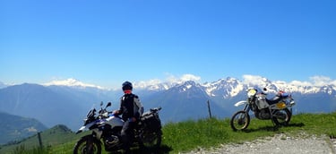 two people on a mountain top with mountains in the background