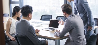 a man and woman sitting at a table with laptops