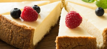 a cake with a slice of cheesecake on a wooden board