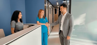 Un paciente estrechando la mano de una odontóloga en la recepción de una clínica moderna,