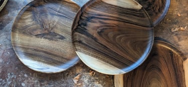 a bunch of wooden plates with wooden bowls and bowls