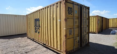 A yellow cargo worthy high cube shipping container with some dents dings rust wind and water tight