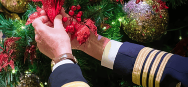 Capitão do navio ajudando na decoração de natal no navio.