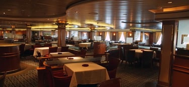 Restaurante elegante a bordo de navio de cruzeiro, com mesas arrumadas. 