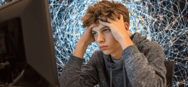 a young man sitting at a computer desk