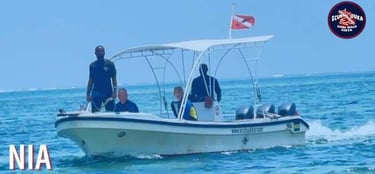 Scuba Duka diving boat carrying divers across the blue ocean water in Diani Beach, Kenya.
