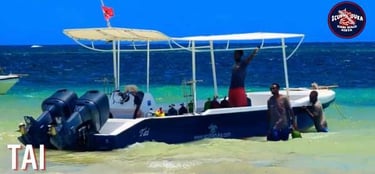 Scuba diving boat Tai by Scuba Duka Diani Beach Kenya with divers in turquoise ocean water.