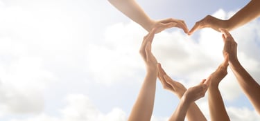 a group of people holding hands in a heart shape