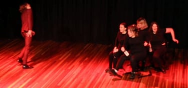 a man standing on a stage with a woman on a skateboard