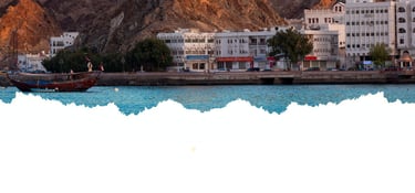 Passeio de barco em Muscat com vista para o Corniche, revelando a orla elegante.
