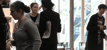a group of people standing around a table