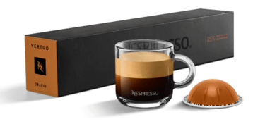 xícara de café com cápsula e caixas de cápsulas nespresso
