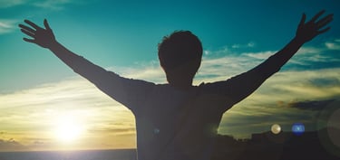 homme levant les bras face au soleil. nouveau depart grace au magnetisme