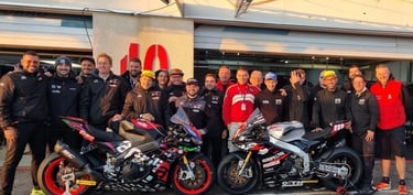 a motorcycle racing team standing around a motorcycle