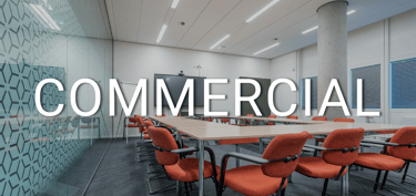Modern commercial office conference room with orange chairs and a large wooden meeting table.