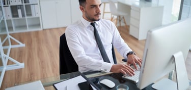 a man in a white shirt and tie is sitting at a desk