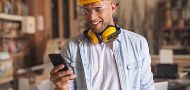 Byggarbetare-med-hjälm-administrerar-med-mobiltelefon