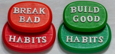 Red and green stones showing the phrases break bad habits and build good habits for self-improvement.