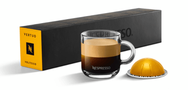 xícara de café com cápsula e caixas de cápsulas nespresso