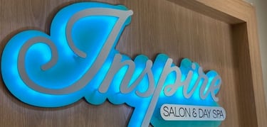 Inspire Salon and Day Spa logo sign displayed above the reception desk is stylish and relaxing.