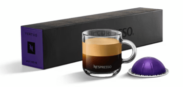 xícara de café com cápsula e caixas de cápsulas nespresso