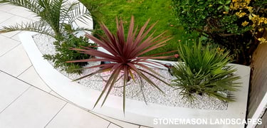 Modern chic raised porcelain patio with white rendered walls and planters