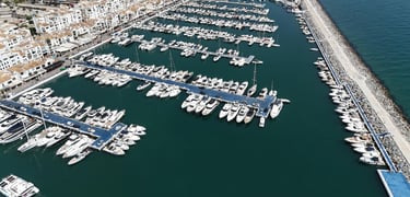 Aerial view of luxury yachts and boats moored in the Puerto Banus marina in Marbella, Spain.