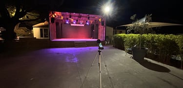 Scène extérieure la nuit avec éclairage violet et un sonometre sur un trépied