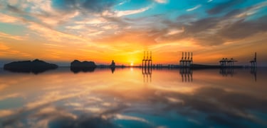 a sunset with a sailboat in the water. arbab naimat kasi , pakistan, karachi