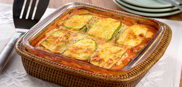 Lasanha low carb de abobrinha com carne moída e queijo gratinado, servida em um prato branco