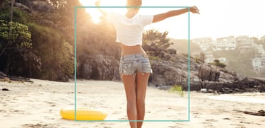 a woman standing on a beach with her arms up and arms outstretched out