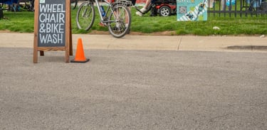 Photo of the event in the Logboat green area with the "Wheelchair & Bike Wash" sign in the road