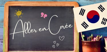 Tableau noir posé sur une table en bois avec l’inscription manuscrite  Aller en Corée