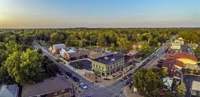 AERIAL VIEW OF DOWNTOWN POWELL OHIO DURING THE DAY SHOWING THE CITIES BUILDINGS AND PARKS