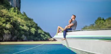 A couple sitting at the edge of a white speedboat, enjoying the sun during their honeymoon on Samui