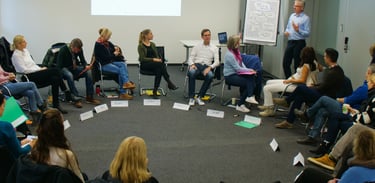 Workshopteilnehmende im Kreis beim Achtsamkeitstraining für Führungskräfte und Teams. Workshop mit Michael Ihli. 