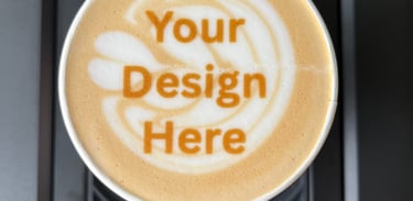 A latte with "your design here" on top of the latte art