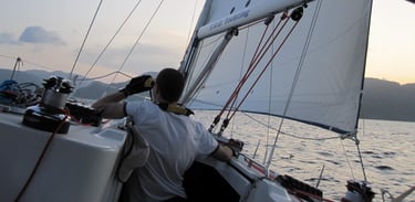 a man in a white shirt is sitting on a boat. Copyright Vincent Volpe