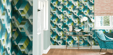 Modern living room featuring geometric teal and green patterned wallpaper with a gold console table.