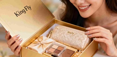 A woman smiling as she unboxes a luxury GWP gift set containing a gold cosmetic pouch.