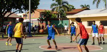 A vibrant South American / Brazilian community sports court where youth are engaged in a playful activity, bright daylight, high-end photography style.