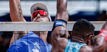 a man in a white shirt and sunglasses playing beach volleyball