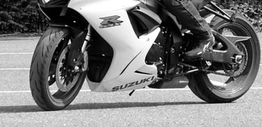 black and white photograph of a Suzuki GSXR in a car park riding slowly
